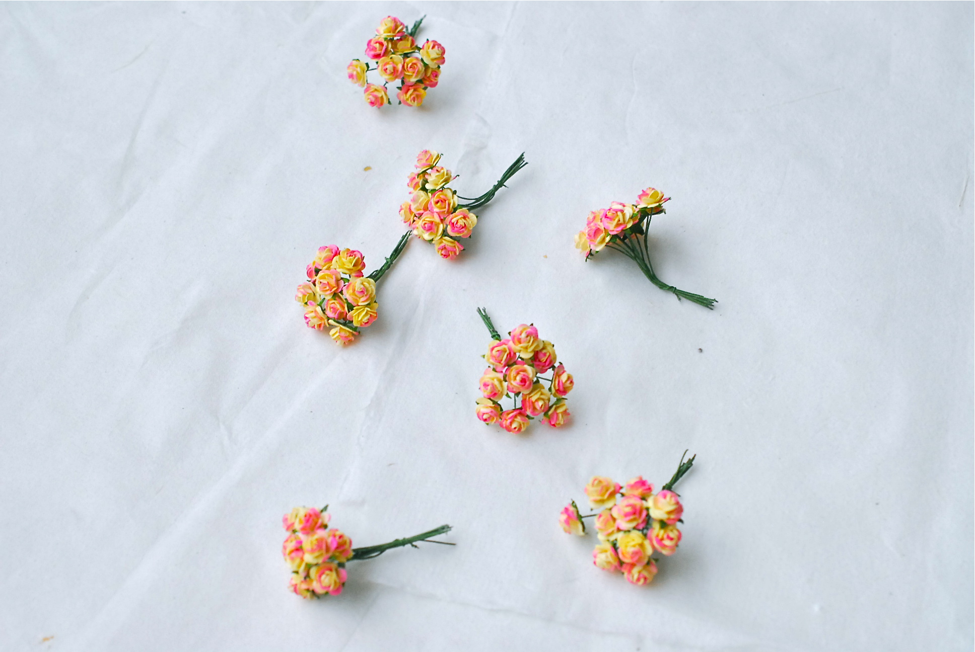 ดอกไม้กุหลาบกระดาษ ดอกกุหลาบจิ๋ว ดอกกุหลาบกระดาษสา ดอกไม้ข้อมือเพื่อนเจ้าสาว ช่อดอกไม้ติดอกเจ้าบ่าว หรือตกแต่งของชำร่วย ดอกไม้กระดาษสาสีเหลืองปัดสีชมพูบานเย็นขนาด 1.5 cm. จำนวน 100 ดอก Paper Flowers size 1.5 cm., mini roses yellow brush pinky color, 100 p