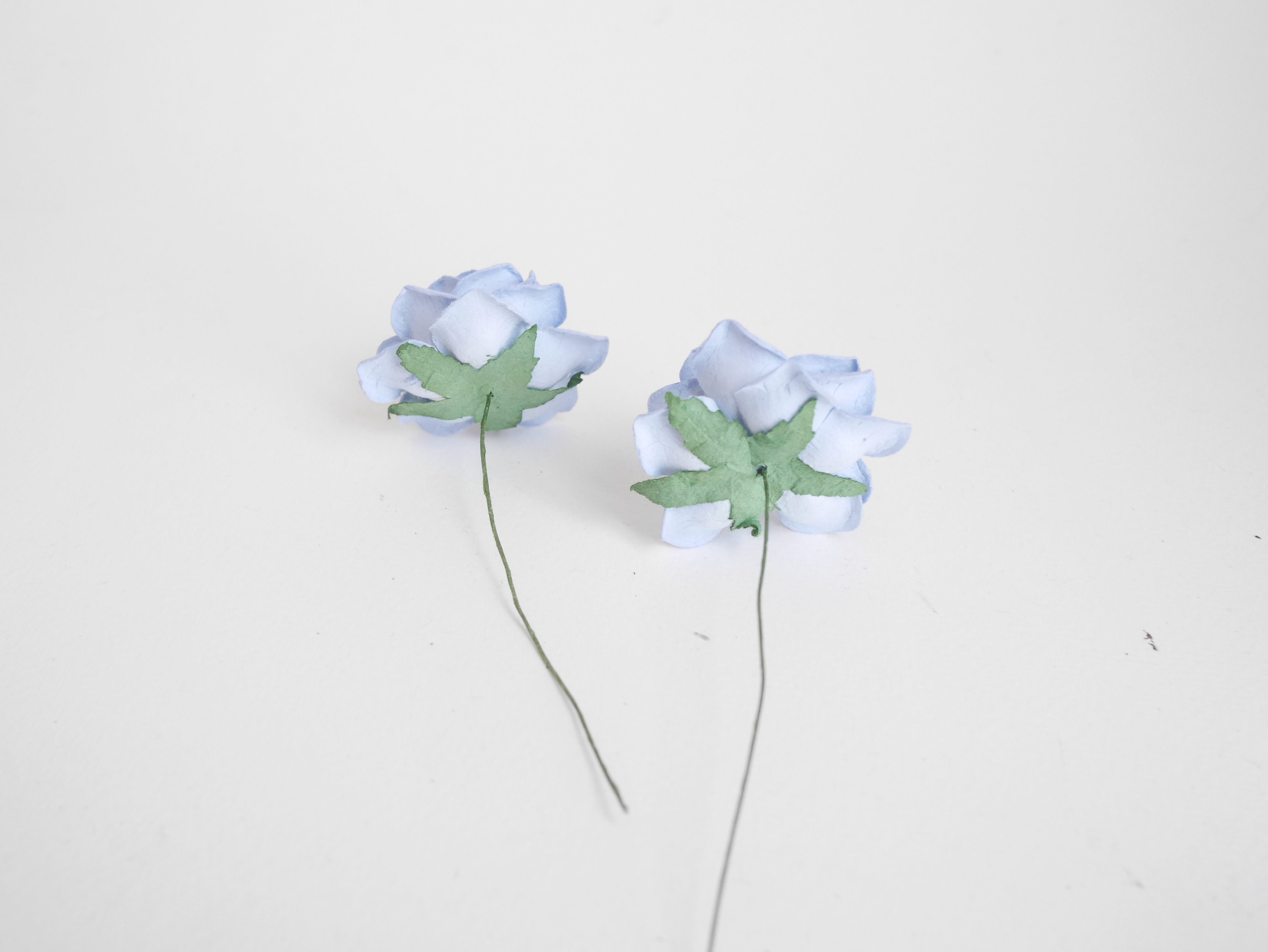 ดอกไม้กระดาษสา ดอกกุหลาบกระดาษสา ดอกไม้กุหลาบ กลีบโค้ง ดอกไม้ประดิษฐ์ สำหรับตกแต่ง หรืองานแต่งงาน สีน้ำเงินตุ่น ขนาด 3.5 cm. จำนวน 25 ดอก Paper flowers, handmade flowers, small roses paper size 3.5 cm. 25 pieces, pale blue color.