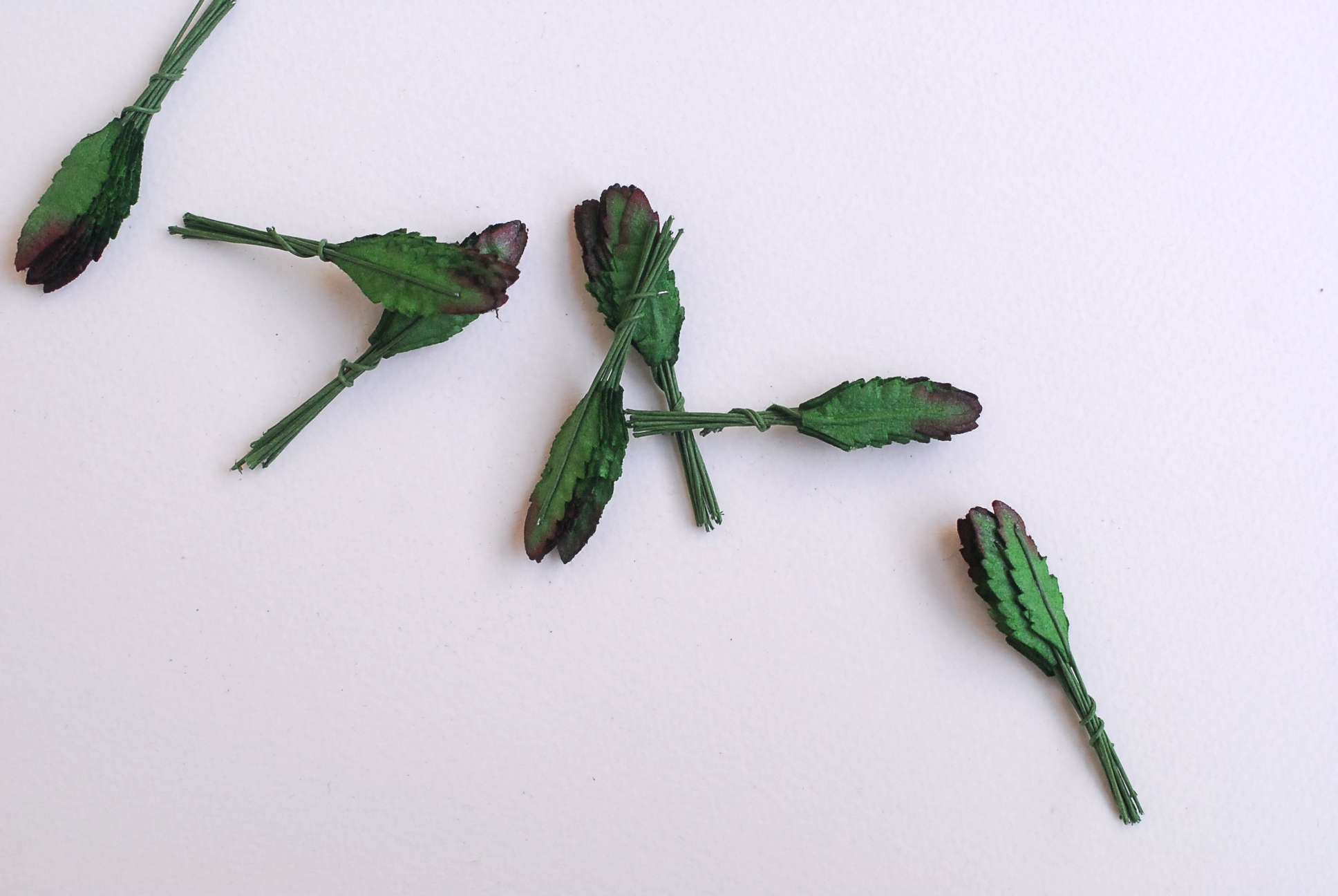 ใบไม้กระดาษ ใบไม้กระดาษสา ราคาส่ง,ใบไม่้กุหลาบกระดาษ สำหรับดอกมะลิกระดาษสา ใบไม้ประดิษฐ์ สำหรับตกแต่ง หรืองานแต่งงาน สีเขียวเข้มปัดสีแดง ขนาด 1.00x2.5 cm. จำนวน 100 ใบ