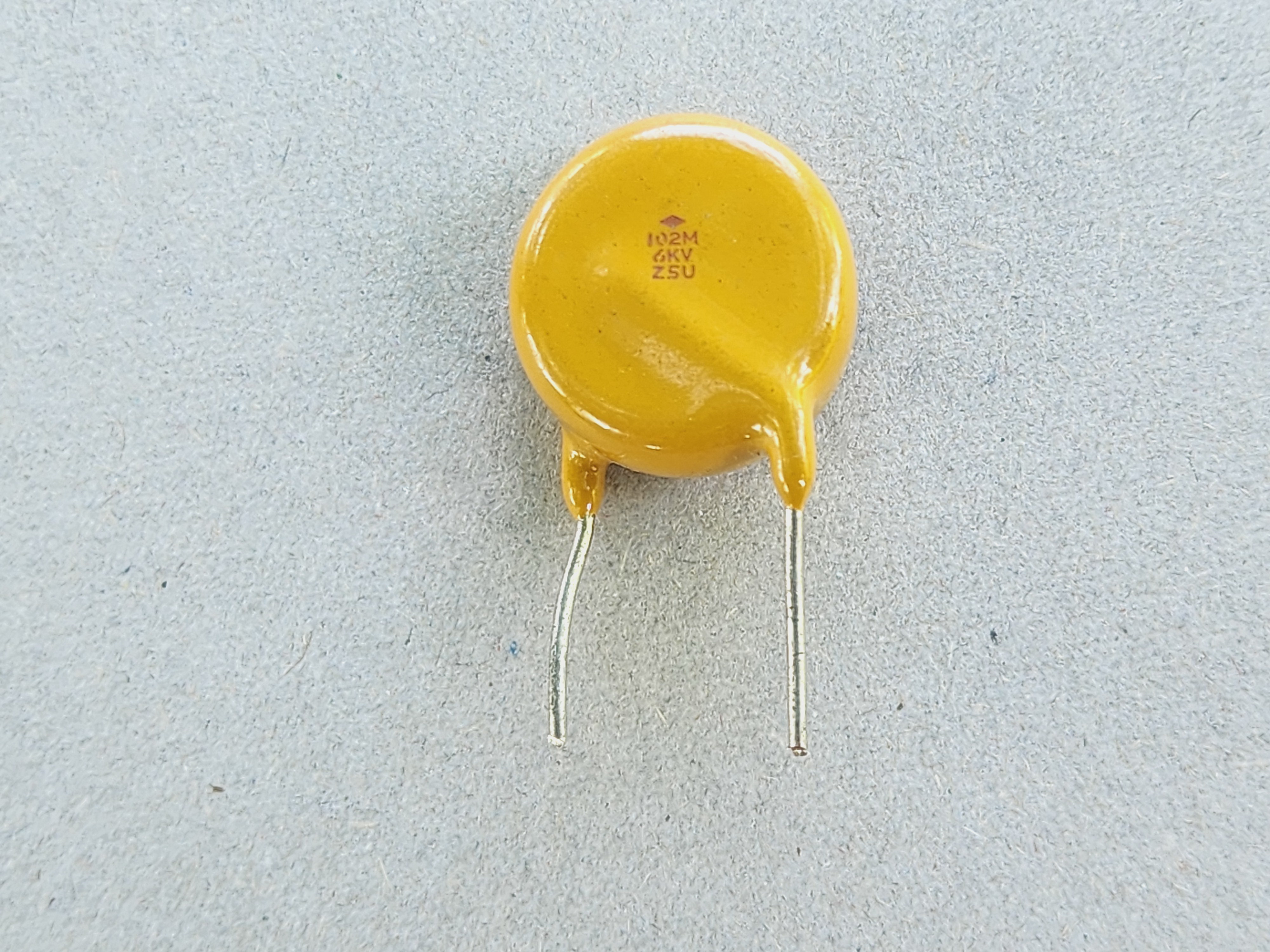 รูปคาปาซิเตอร์ชนิดเซรามิค และสัญลักษณ์ เป็นคาปาซิเตอร์ไม่มีขั้ว